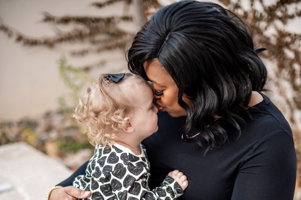 Mom and daughter kisses for adoption photoshoot